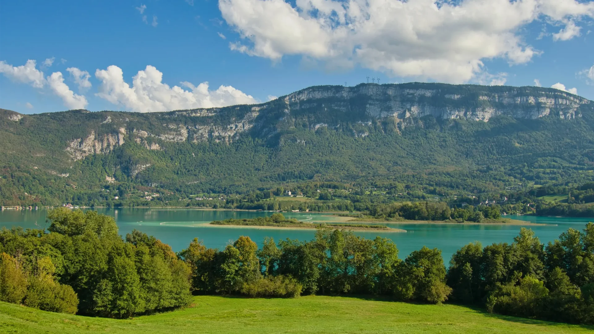 Camping dans la région Auvergne-Rhône-Alpes avec paysages de montagnes et lac, idéal pour des vacances ressourçantes.